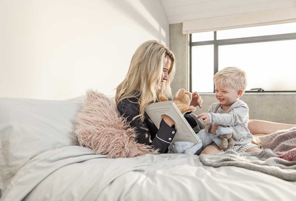 A mother and toddler playing together on a SleepMaker bed
