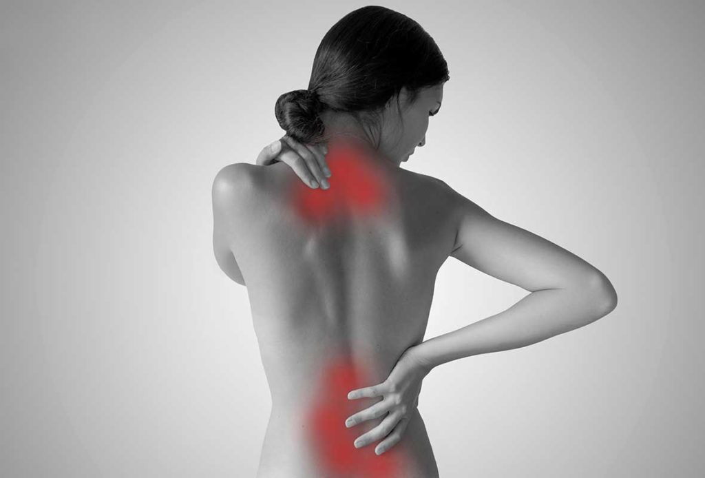 A black and white photo of a woman's back, with red around her cervical and lumbar spine areas