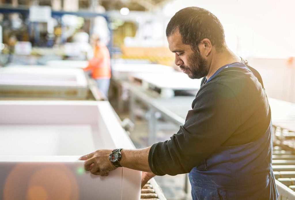 A man in an Australian factory assembling a SleepMaker mattress