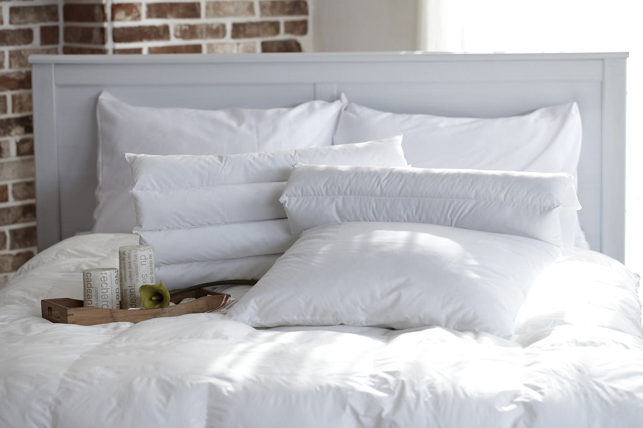 A luxurious bed covered in comfortable pillows and a duvet