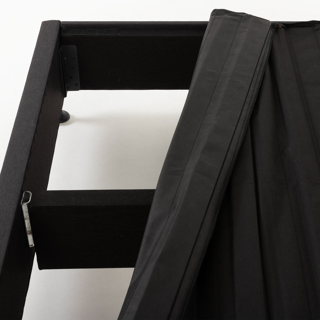 Close-up of a black fabric-covered SleepMaker Connect kitset bed frame, showing the interior structure and metal support against a plain white background.