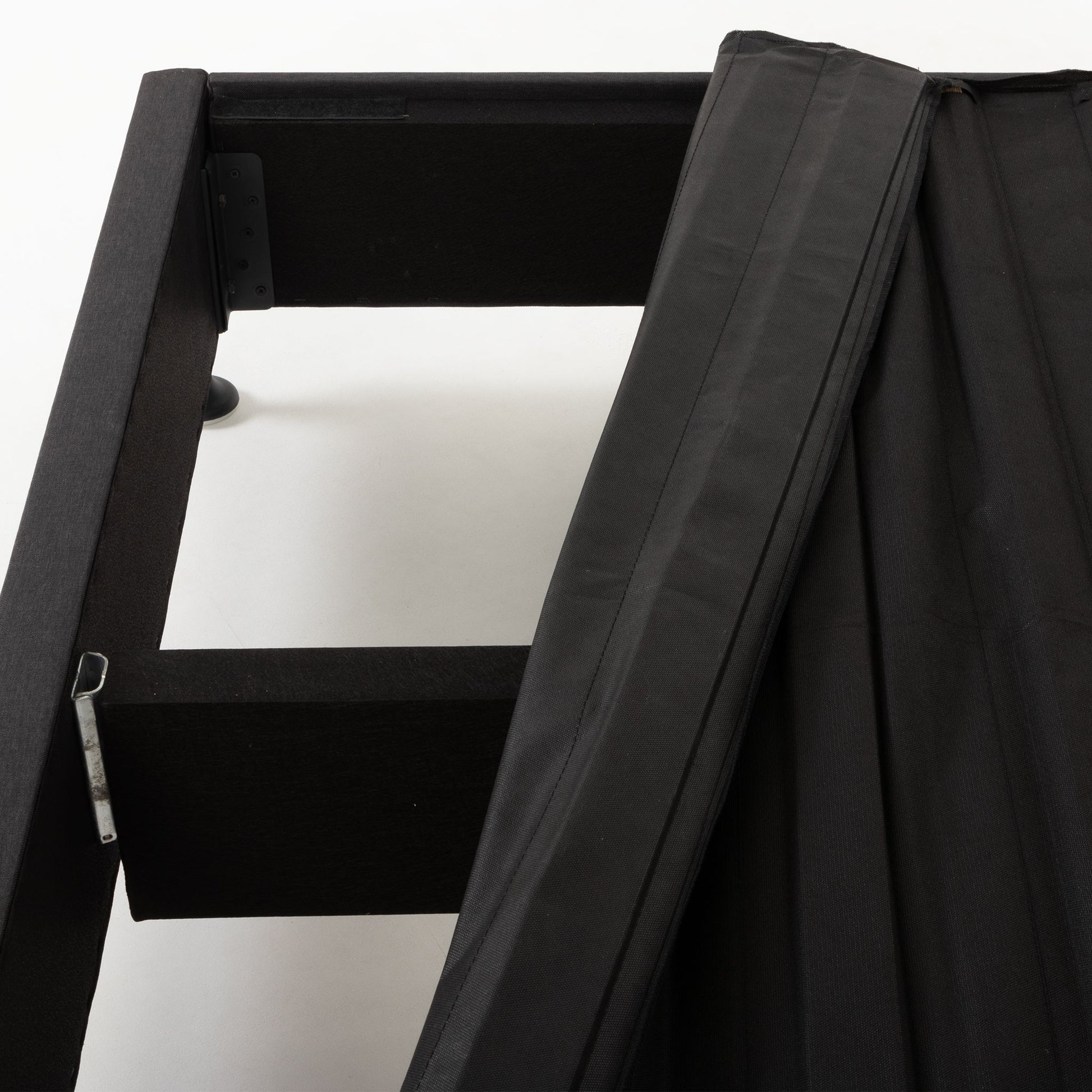 Close-up of a black fabric-covered SleepMaker Connect kitset bed frame, showing the interior structure and metal support against a plain white background.